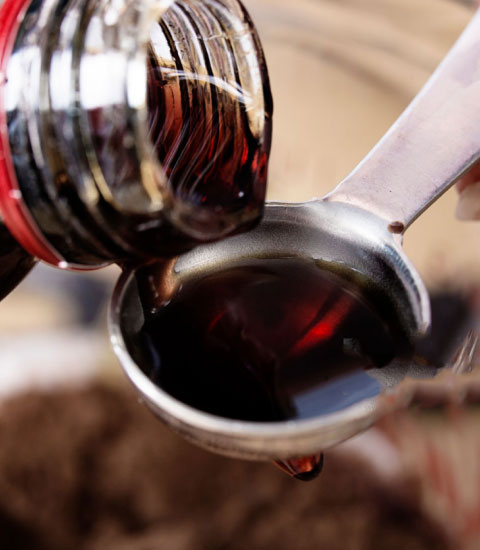 Extract being poured into a measuring spoon.