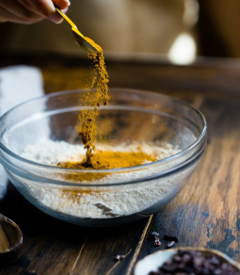 Spices being mixed into a bowl.